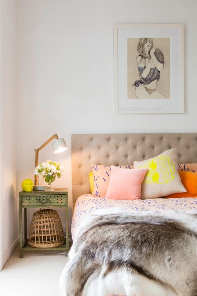 tan tufted headboard with neon pillows